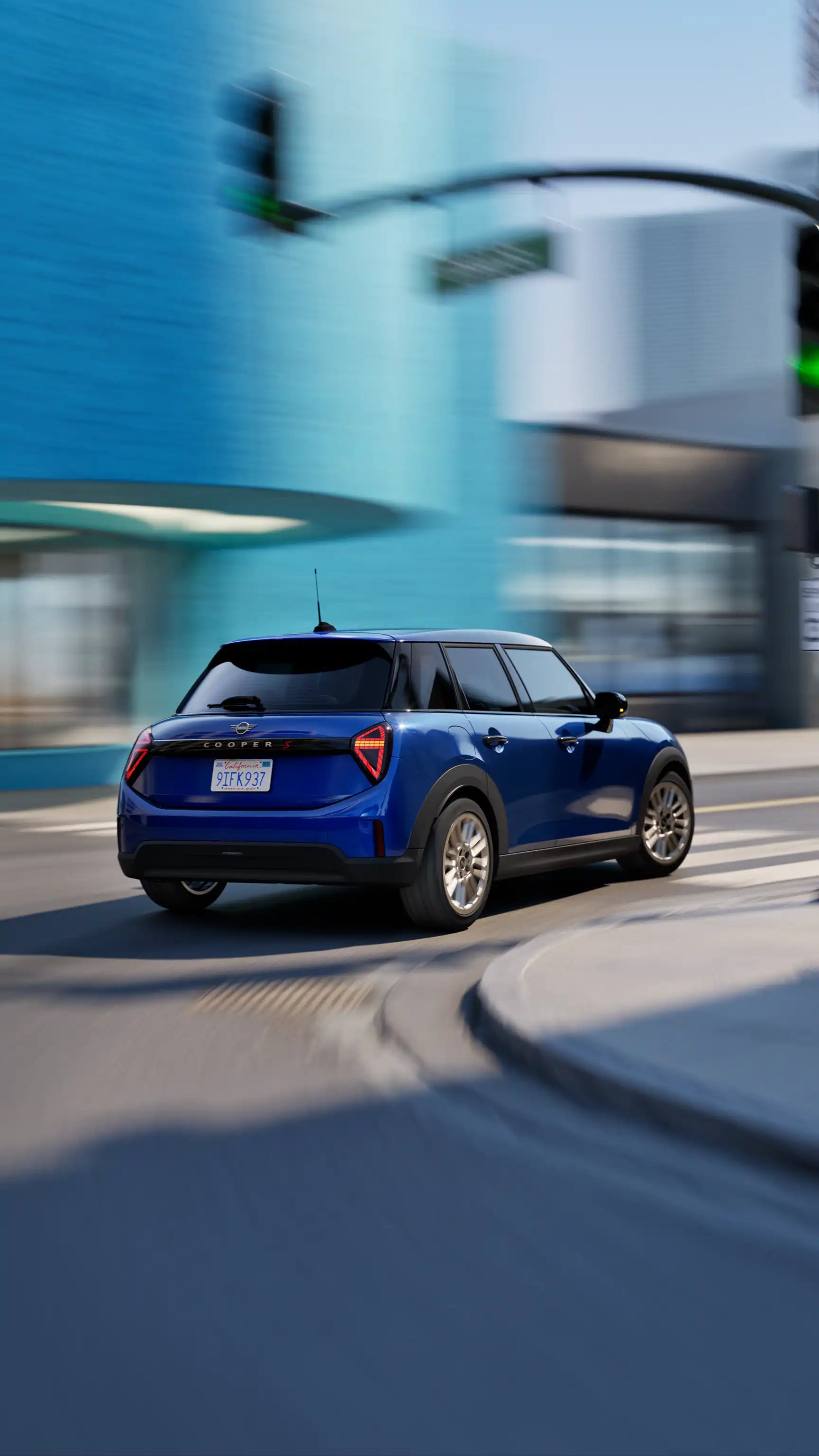 Rear three‑quarter view of a MINI Cooper 5‑Door in Blazing Blue Metallic driving through an urban intersection.