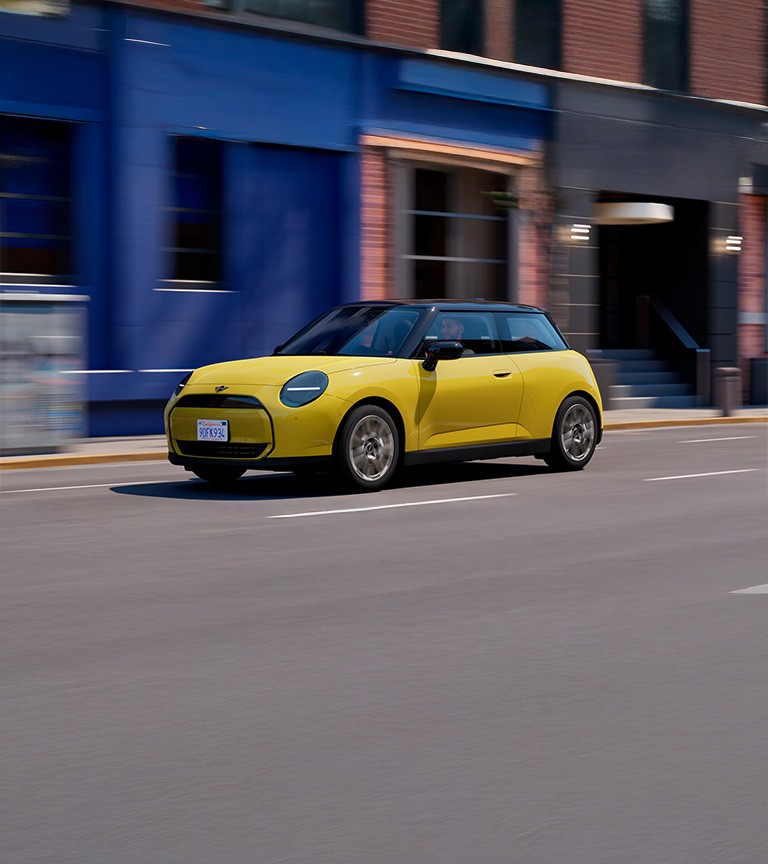 MINI Cooper in Sunny Side Yellow driving on an urban street.