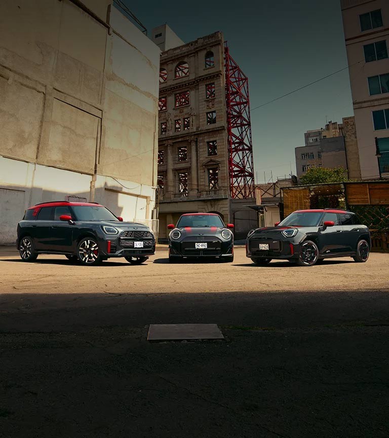 MINI Countryman John Cooper Works in Nanuq White Metallic driving through an urban intersection.